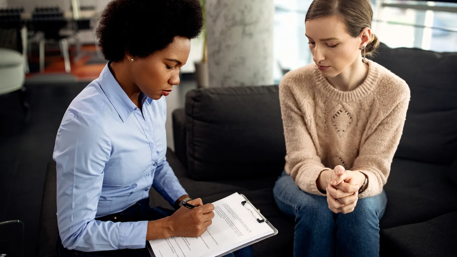 Clinician reviewing a client chart across several documents at a desk